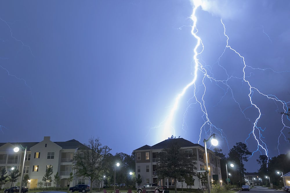 A massive lightning strike over a neighborhood.